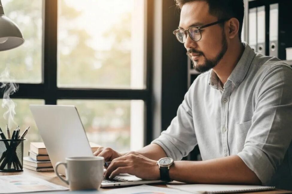 Small business owner reviewing PPC advertising strategies with a laptop and marketing materials